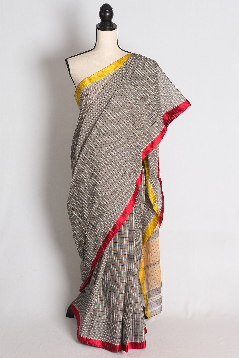 Grey Dhaniakhali Soft Cotton Saree draped elegantly on a mannequin showcasing its contrasting yellow and red border.