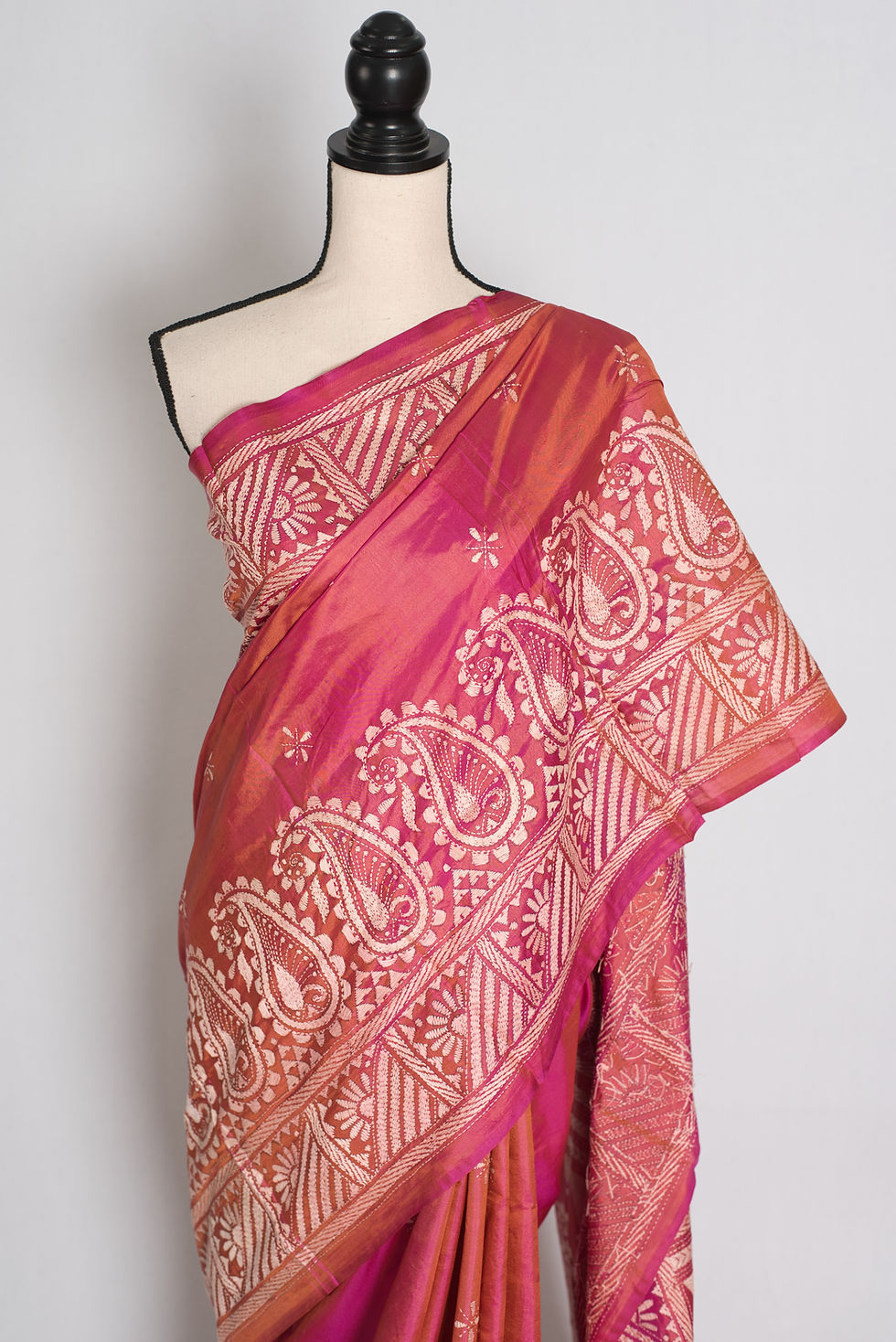 Thumbnail: Coral pink pure Bangalore silk saree featuring hand-embroidered white Kantha stitch paisley borders draped on a mannequin.