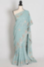 Full view of the soft blue georgette partywear saree spread flat, showing its tone-on-tone floral embroidery.