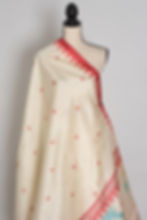 Thumbnail: Cream-colored semi-silk Durga Puja saree on a mannequin, featuring Goddess Durga on her lion, framed by a red border.