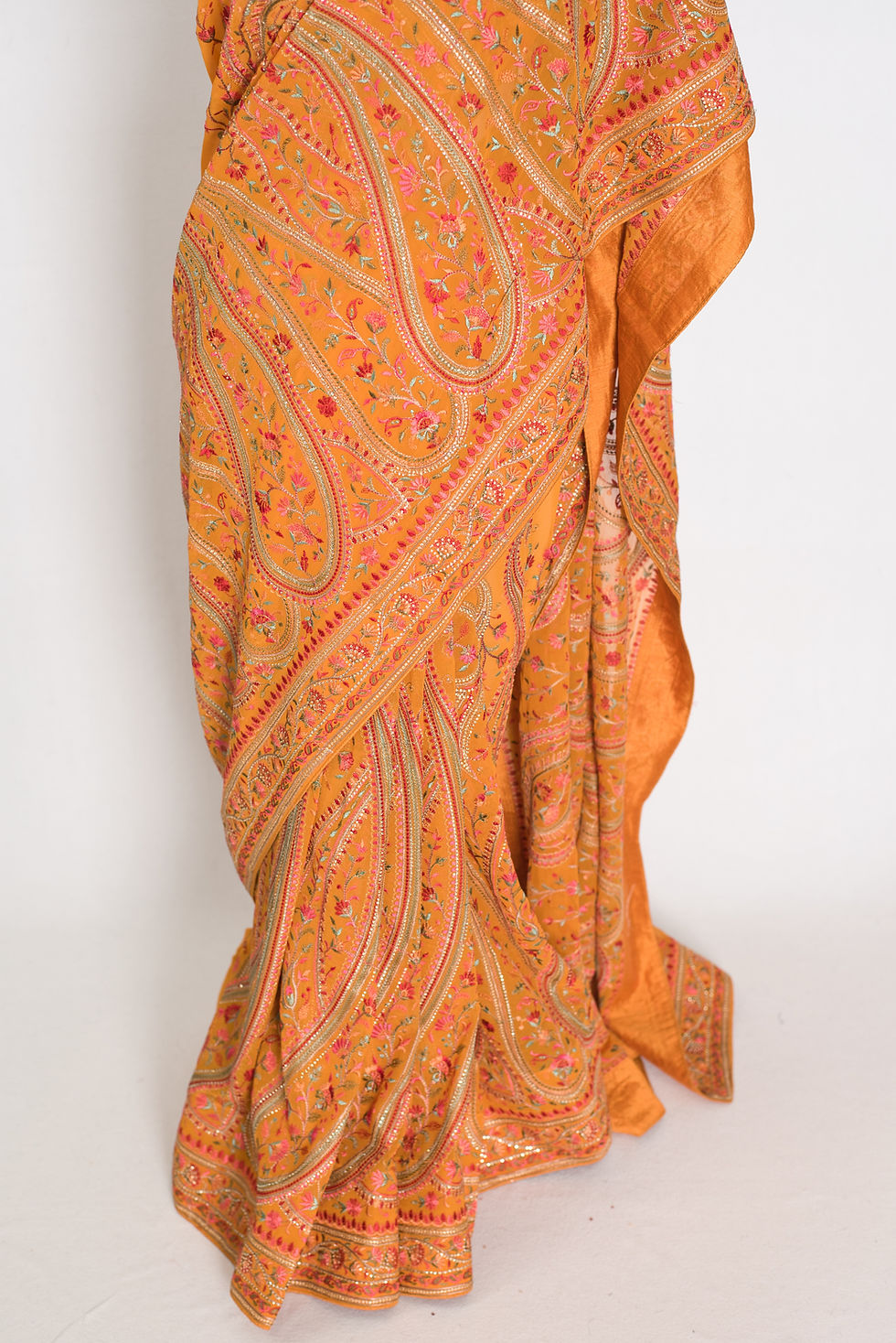 Thumbnail: Turmeric yellow georgette partywear saree on a mannequin showing all-over Kashmiri machine embroidery jaal work.