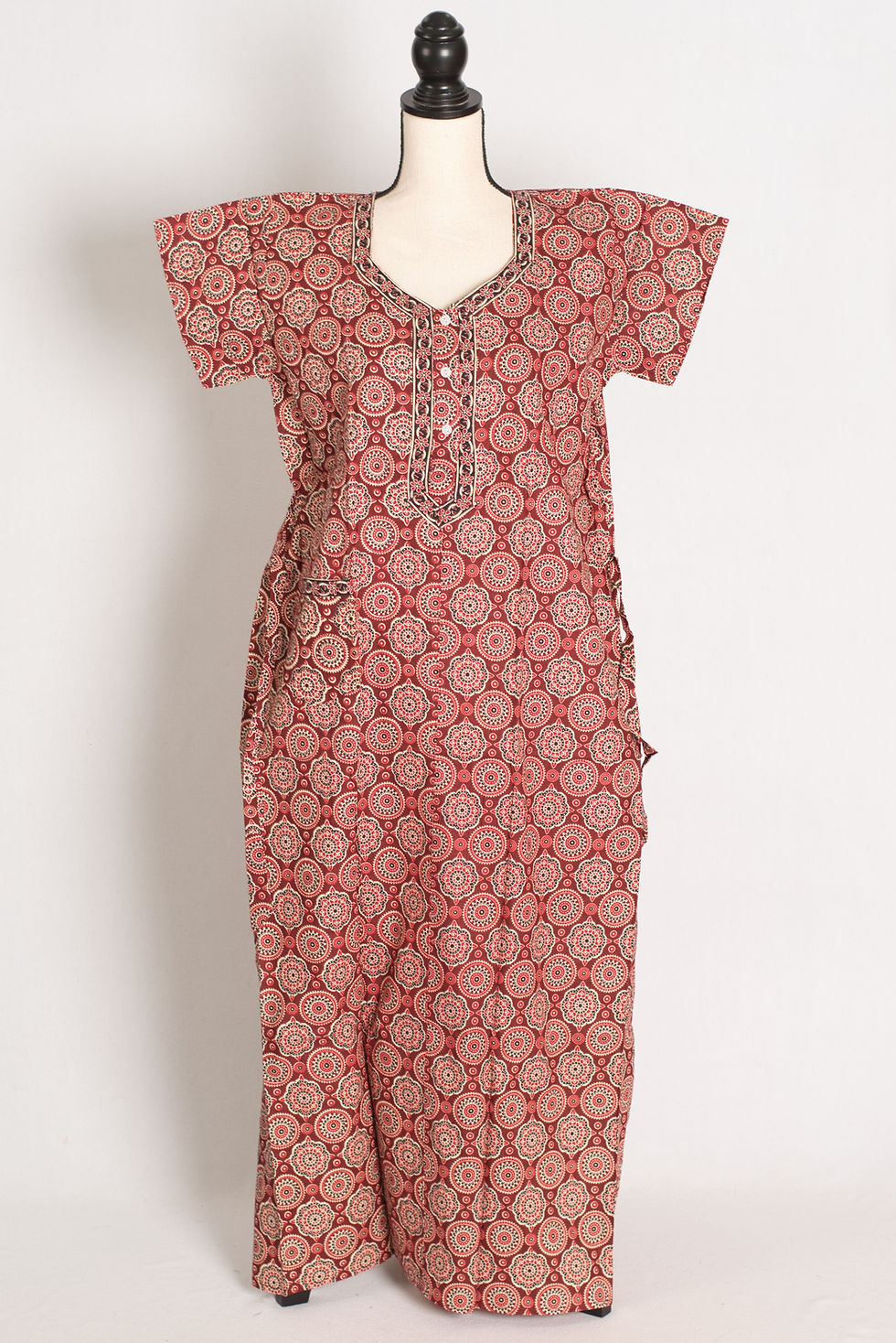 Full-length view of a brick red pure cotton long nighty on a mannequin, showcasing an all-over circular Kalamkari print