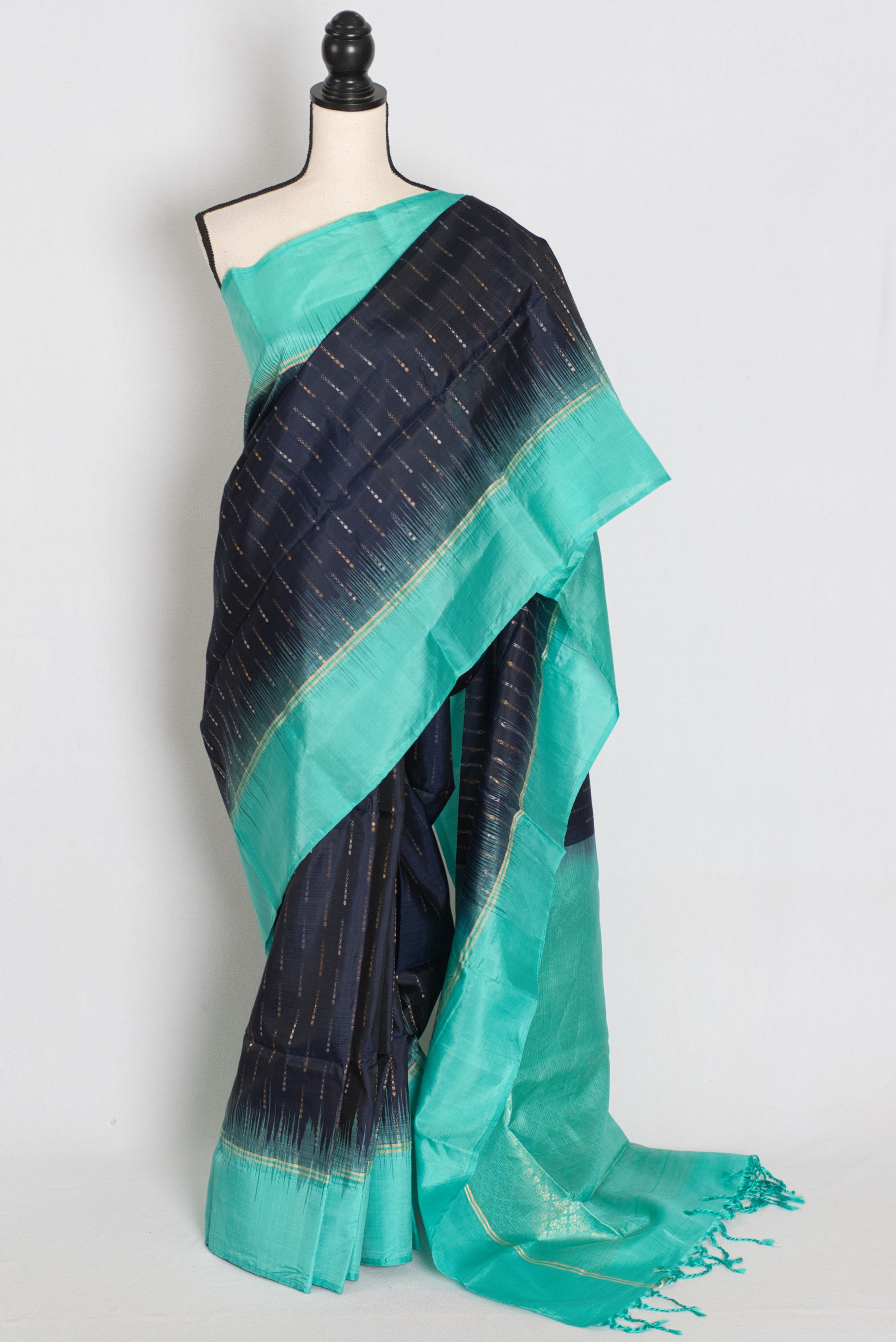 Midnight blue Kanjivaram pure silk saree featuring a vibrant turquoise border and pallu, elegantly draped on a mannequin.