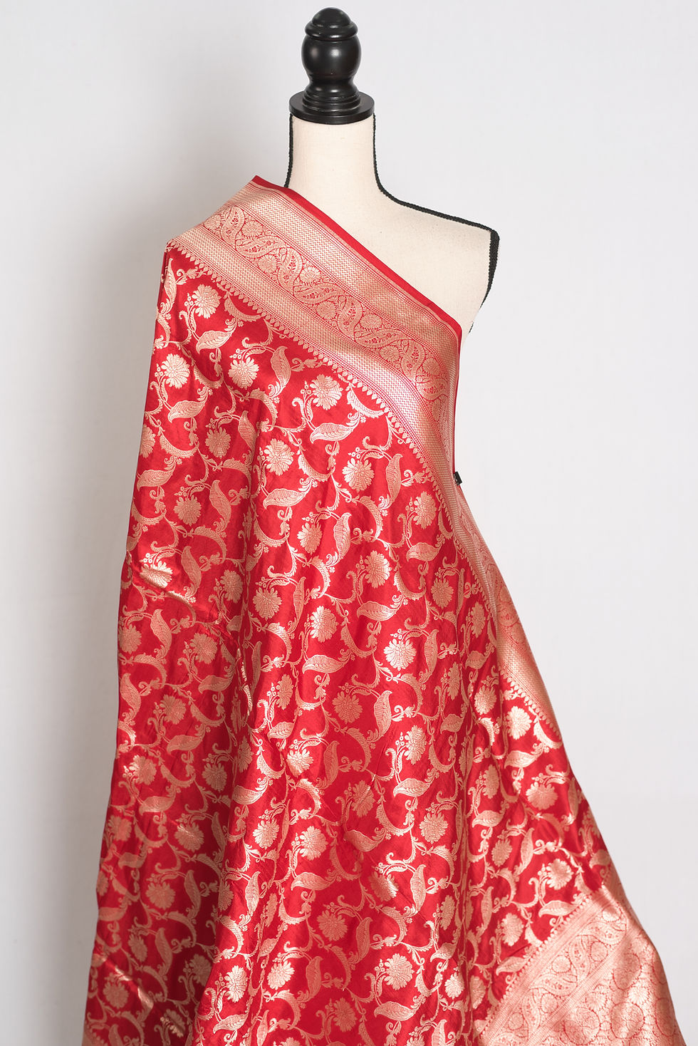 Thumbnail: Red and gold bridal Banarasi Katan silk saree featuring all-over Jangla floral zari weaving, heavy gold brocade border.