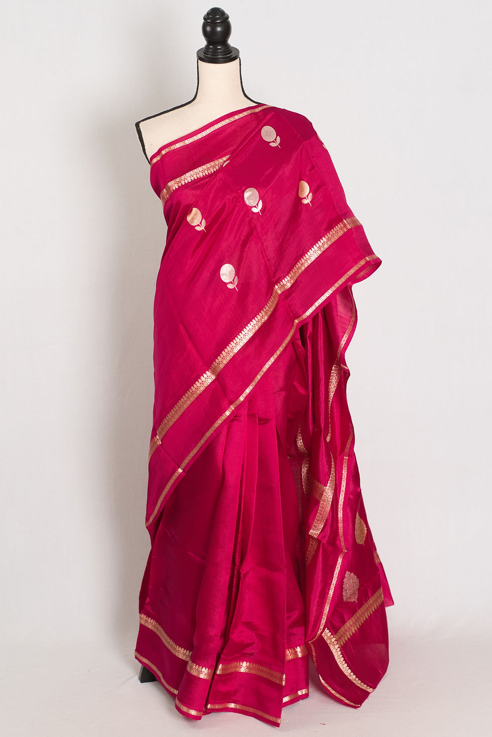 Gauri dark pink pure Katan silk Banarasi saree with gold and silver zari floral motifs on a mannequin.