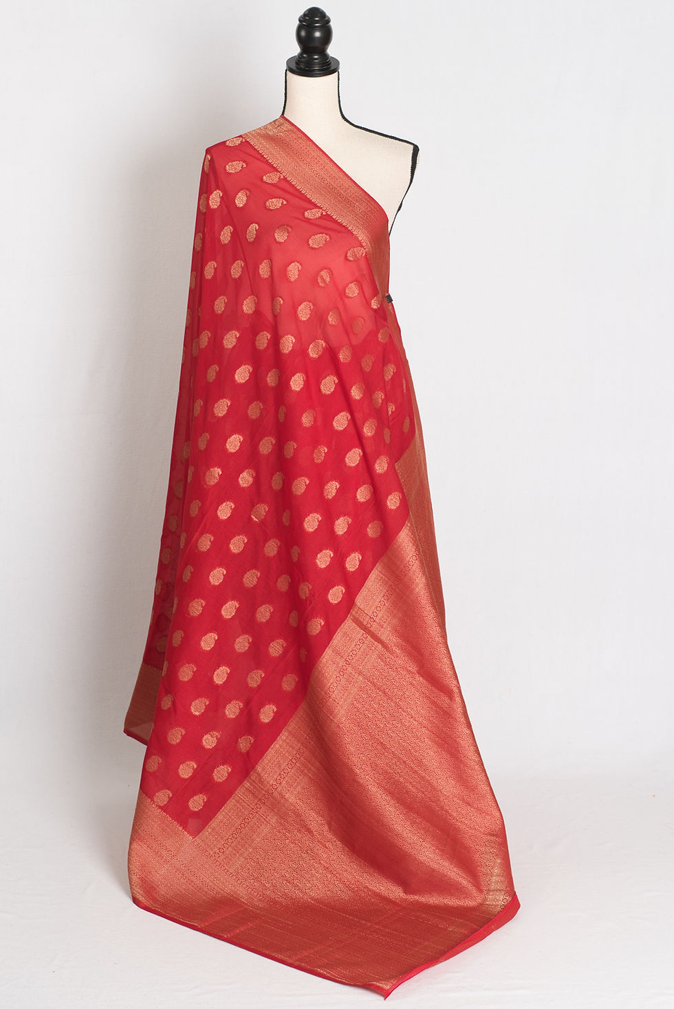 red semi georgette Banarasi saree with gold zari paisley motifs draped on a mannequin.