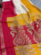 Thumbnail: Vibrant yellow semi chiffon saree with a red temple border and multi-color floral prints.
