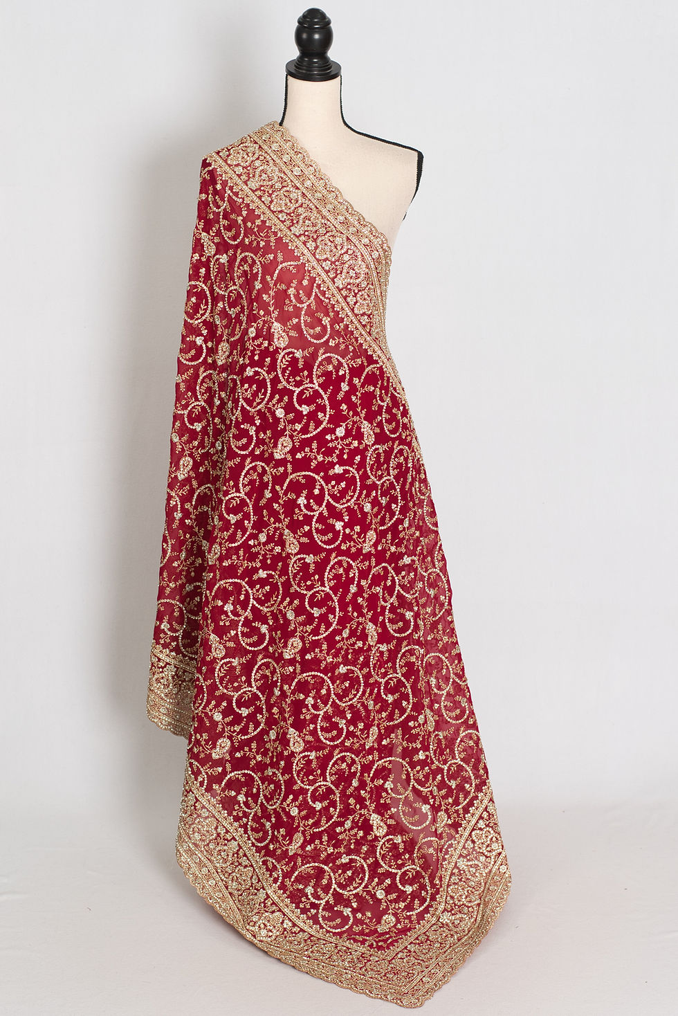 Maroon georgette bridal saree on a mannequin displaying its full-body heavy gold thread embroidery.