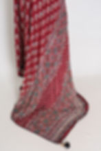 Red semi modal silk partywear saree draped on a mannequin showcasing all-over hand pasted mirror work