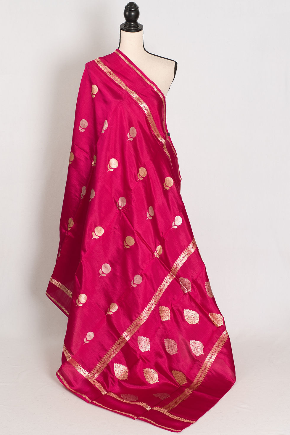 Gauri dark pink pure Katan silk Banarasi saree with gold and silver zari floral motifs on a mannequin.