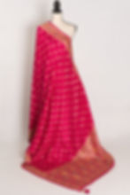 dark pink and gold dola silk banarasi saree draped on a mannequin.