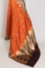 Thumbnail: Bina rust orange and coffee brown handwoven Banarasi silk saree with golden zari temple border on a mannequin.
