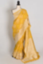 Yellow Bandhani Tussar Georgette Banarasi saree featuring thick silver zari border on a mannequin.