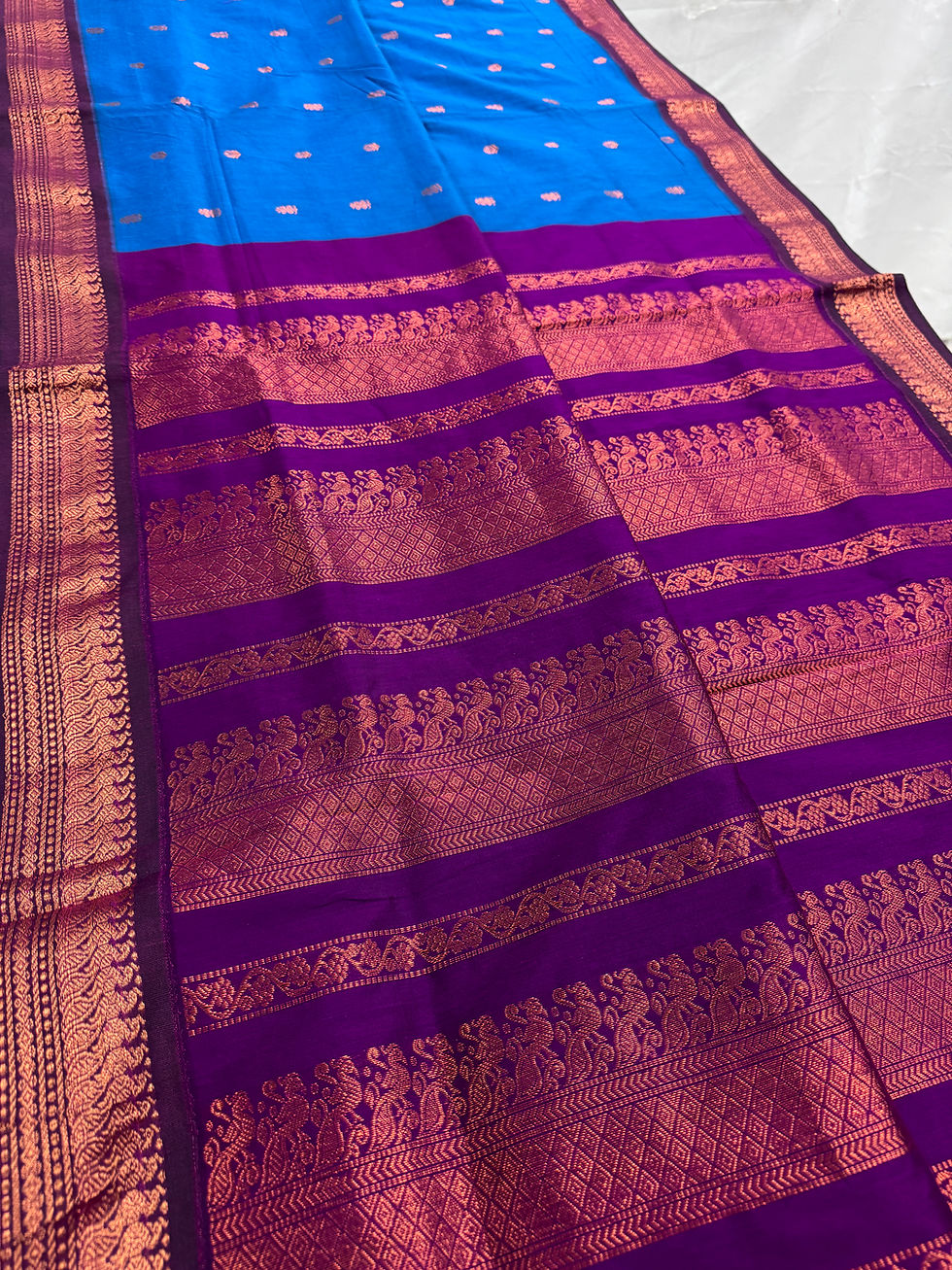 Ankhi bright blue and purple blended cotton Gadwal saree highlighting the intricate copper peacock zari motifs on the pallu.