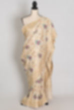 Beige and gold Tussar Georgette Banarasi saree with gold zari jaal and pink, teal, and purple Minakari florals.
