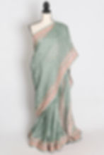 teal green crushed georgette saree with all-over intricate floral machine embroidery and pink border on a mannequin.