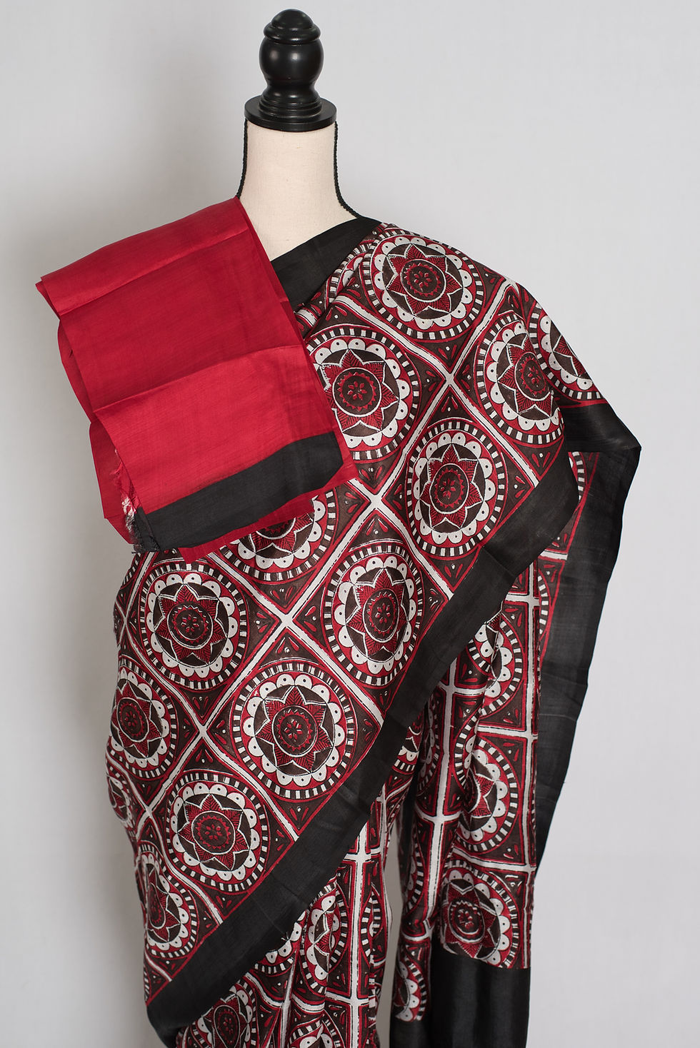 Thumbnail: Black and red Murshidabad silk saree with a contemporary hand block printed mandala grid design draped on a mannequin.