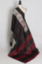 Black and red half and half Murshidabad silk saree with hand block printed tribal face motifs draped on a mannequin.