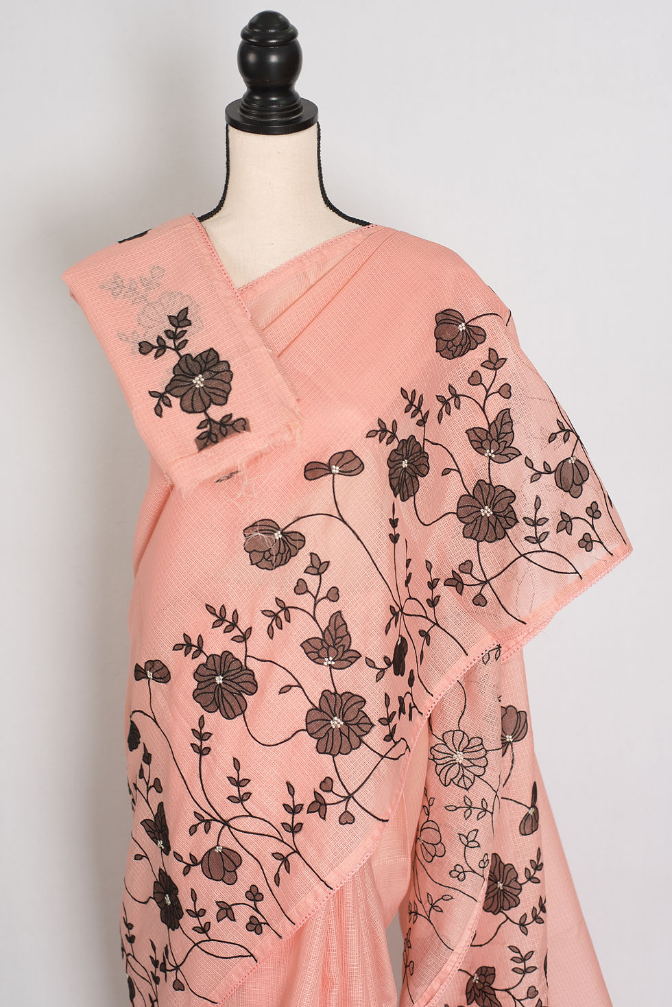 Thumbnail: Soft peach and black semi kota silk saree with floral appliqué work and black machine embroidery.