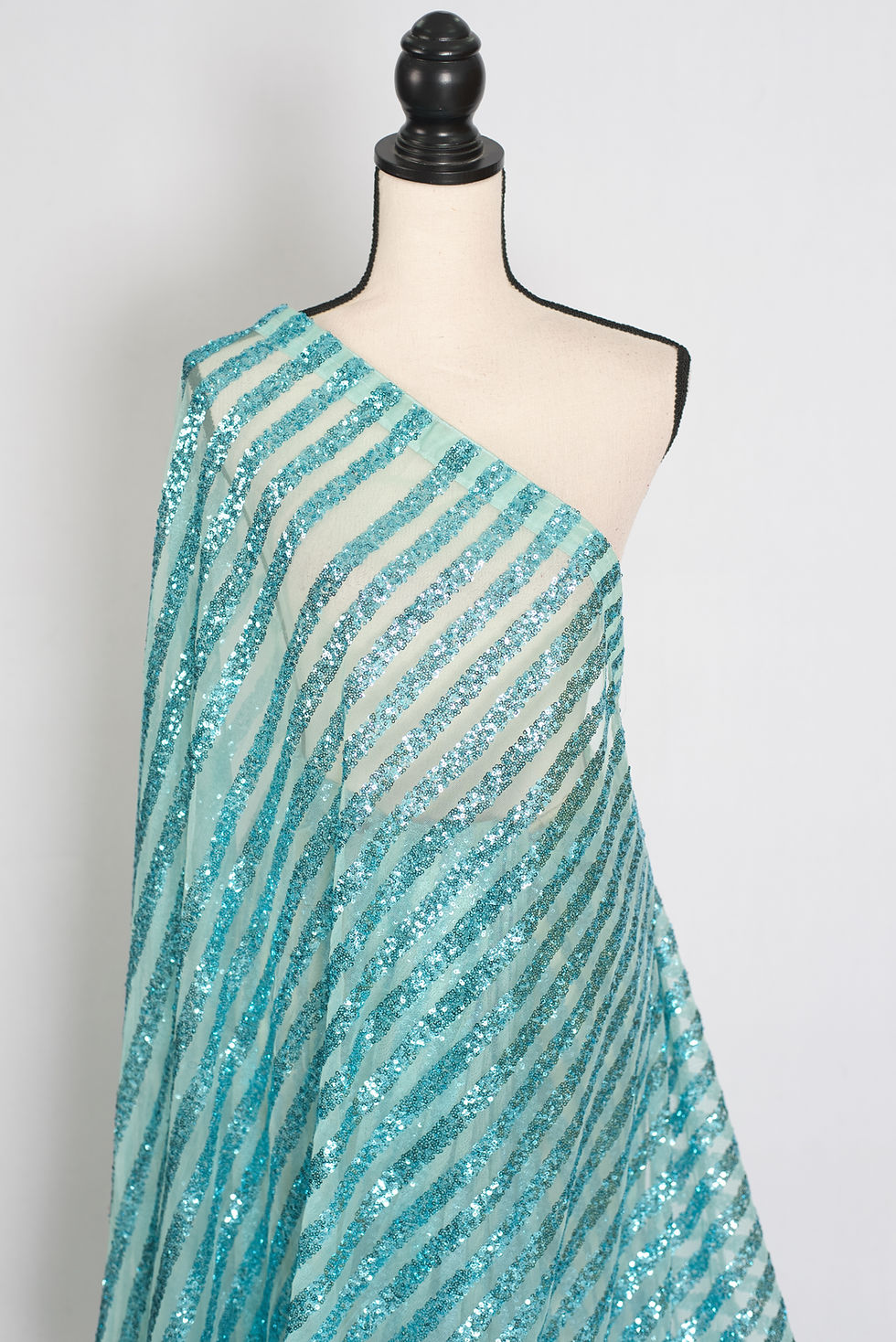 Thumbnail: Turquoise blue sequin partywear saree on a mannequin showing its lightweight fluid drape and trending linear shimmering strip
