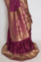 Thumbnail: Flowing pleats of the purple Banarasi silk lehenga skirt featuring floral gold zari motifs and wide brocade borders.