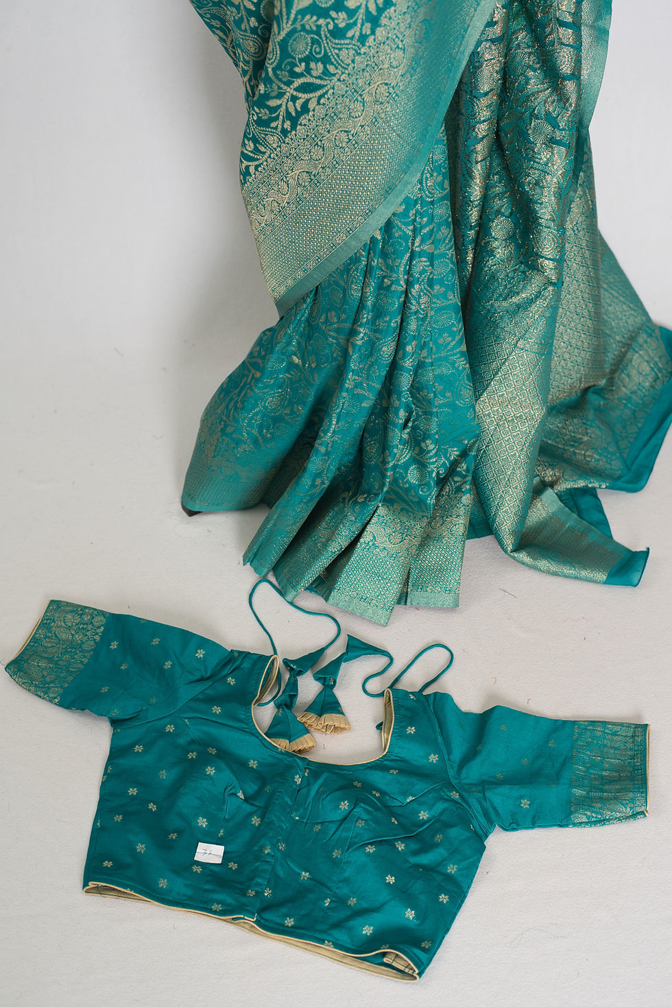 Rama green semi georgette Banarasi saree draped on a mannequin displaying its all-over gold zari jaal.