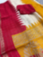 Vibrant yellow semi chiffon saree with a red temple border and multi-color floral prints.
