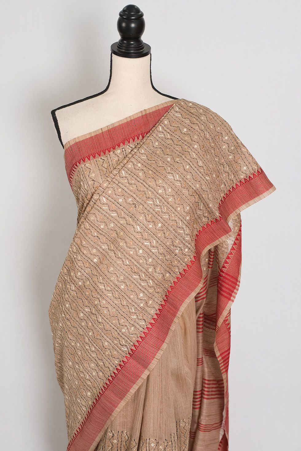 Thumbnail: Traditional beige and red Bengali saree with machine Kantha embroidery on a mannequin.
