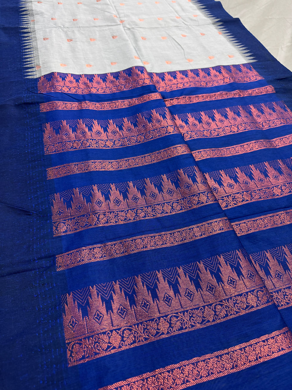 Gray and blue blended cotton saree with copper temple border and matching blouse piece.