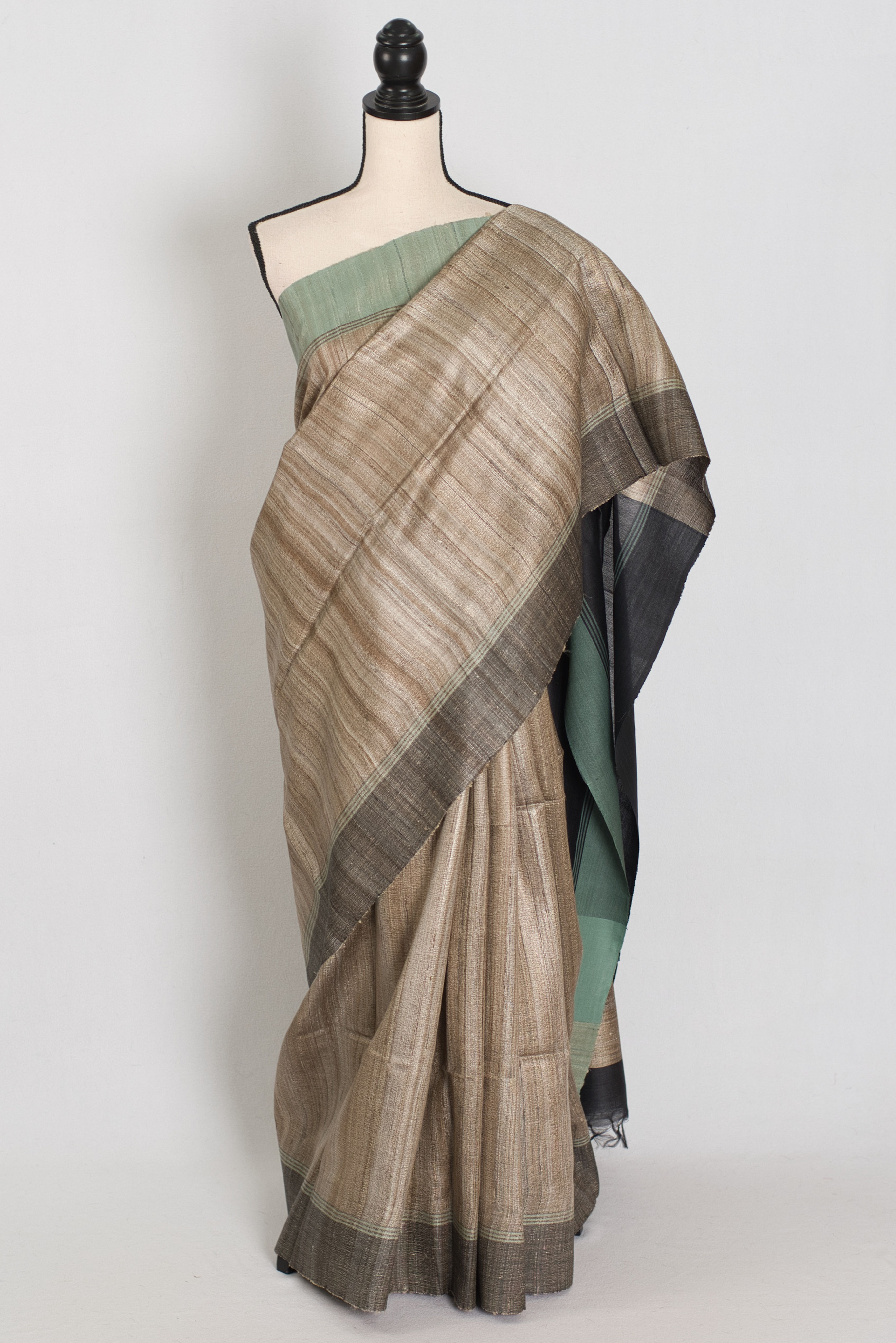 Ketiya Tussar silk saree in natural tan with pastel green and black Ganga Jamuna borders.