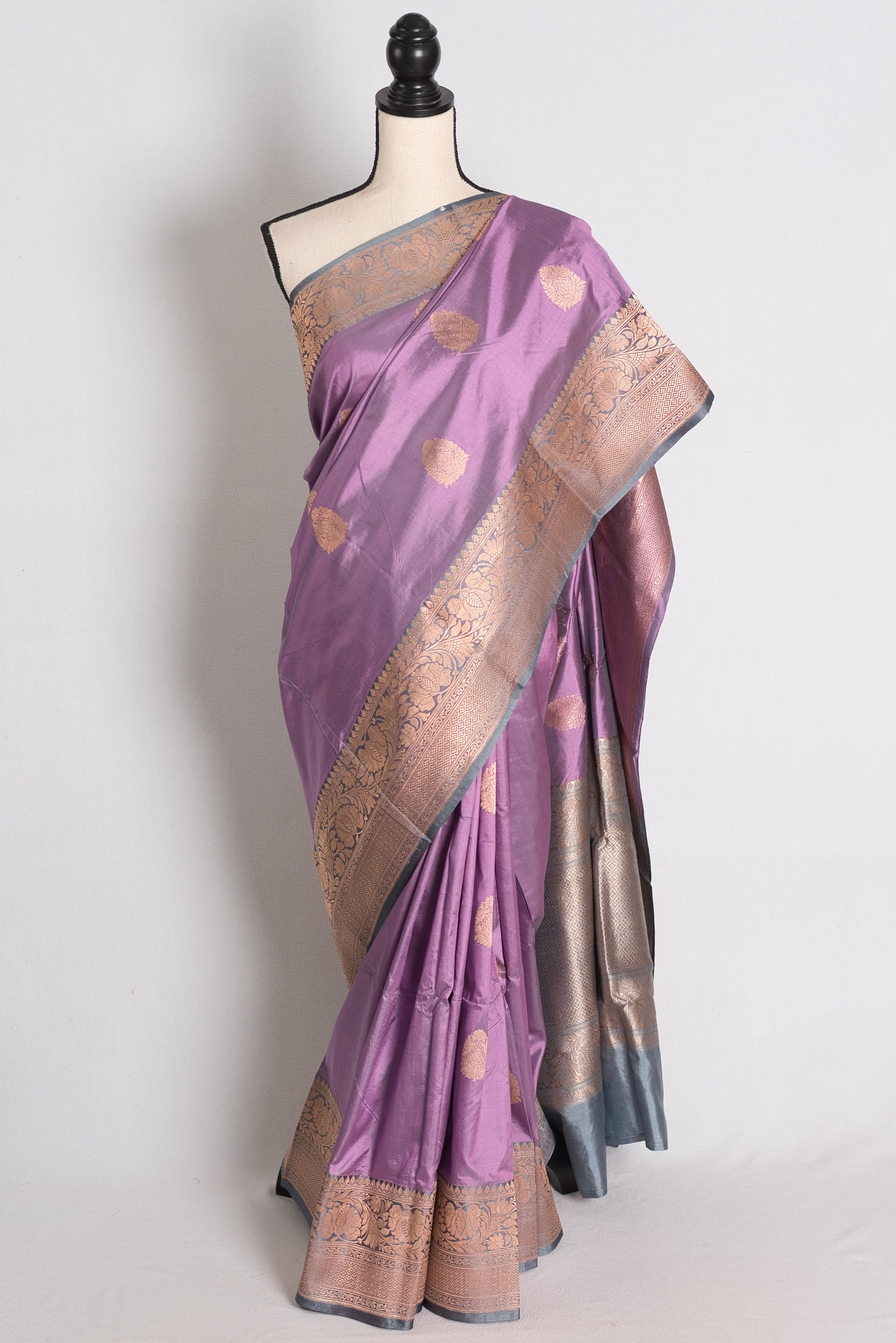 Lilac and Gray Banarasi Silk Saree draped elegantly on a mannequin showcasing its contrasting gray border and gold zari booti