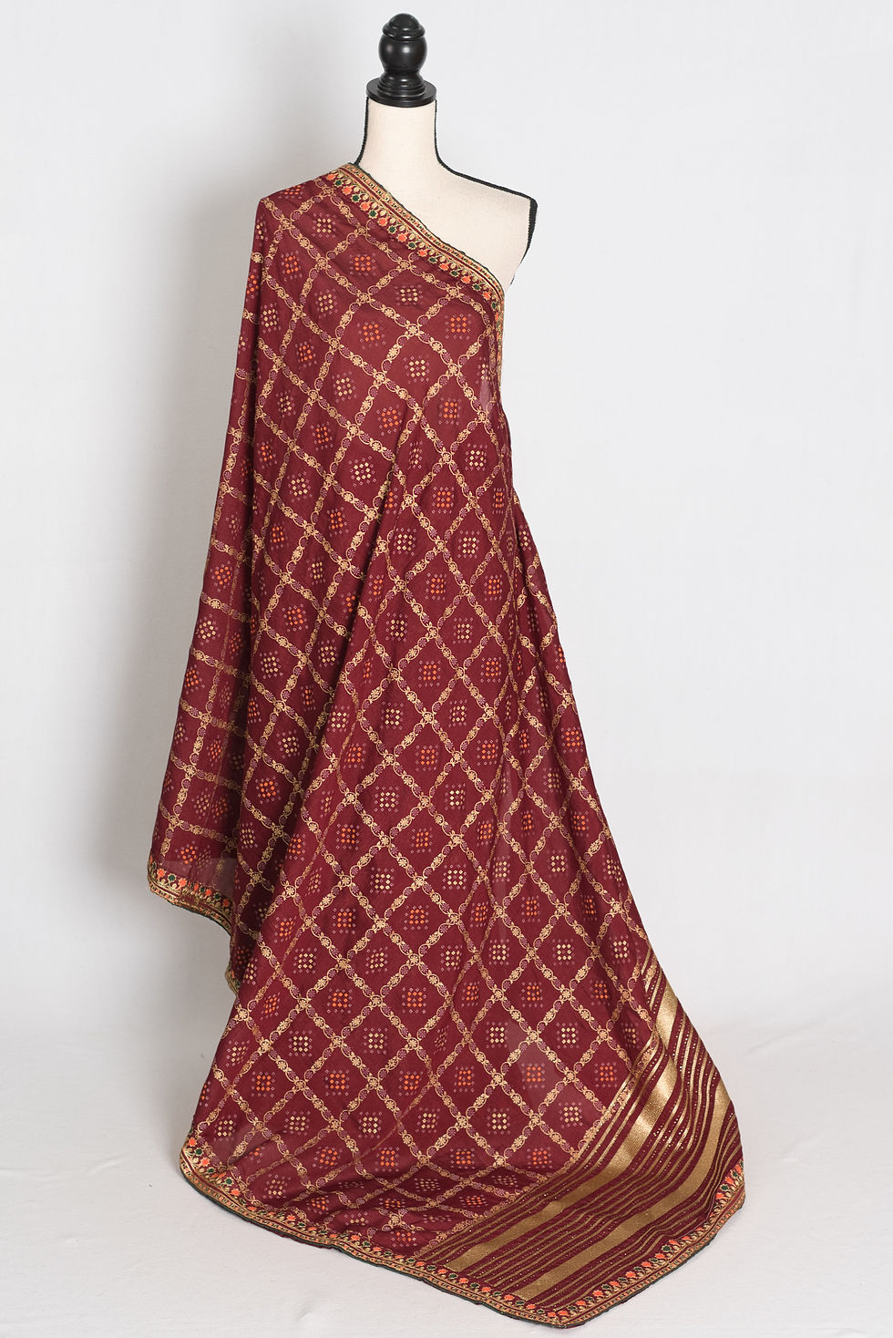 maroon semi Tussar silk saree in a traditional Gharchola gold print pattern on a mannequin.
