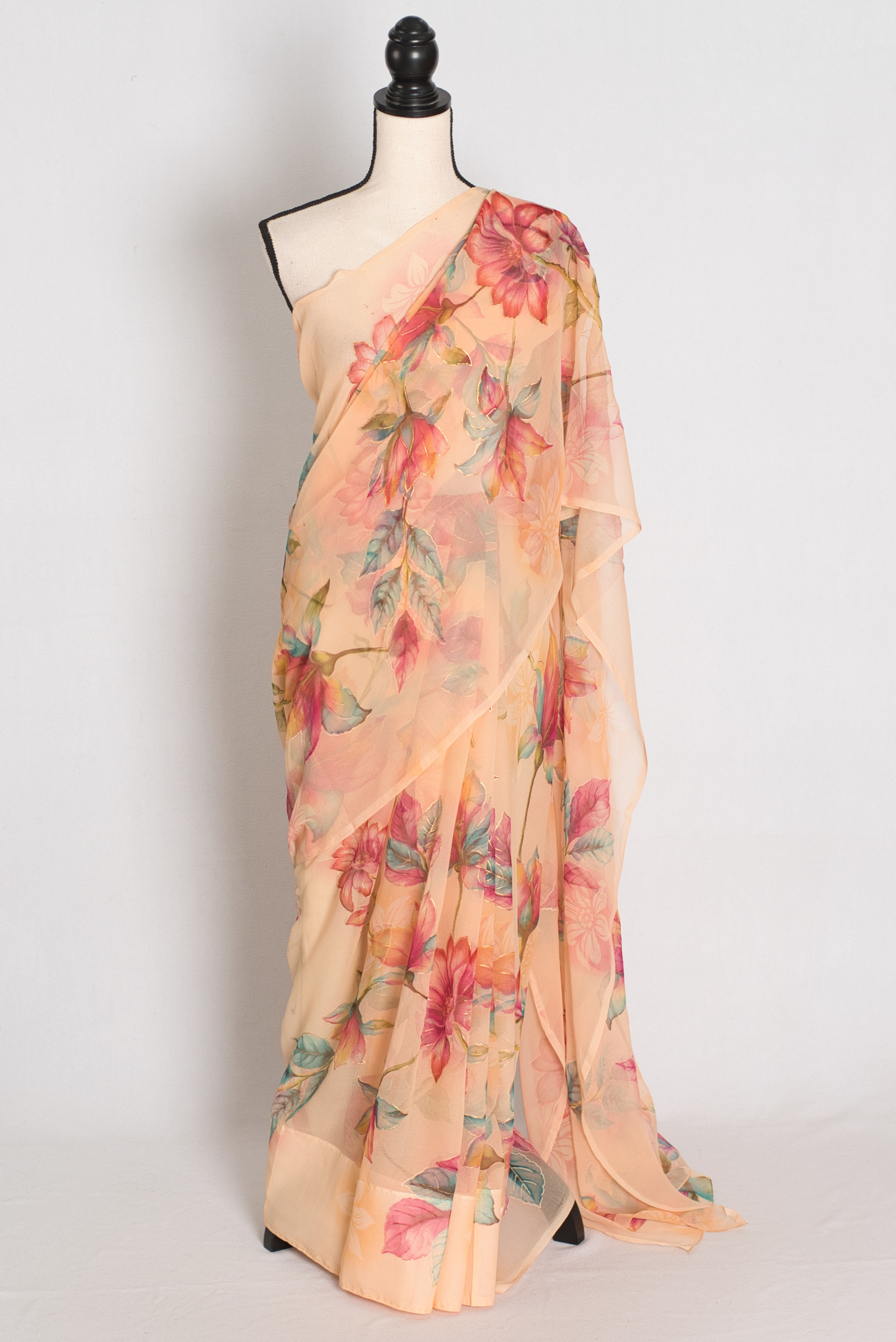 full length front view of Diya soft peach chiffon saree displaying the vibrant floral print draped on a mannequin.