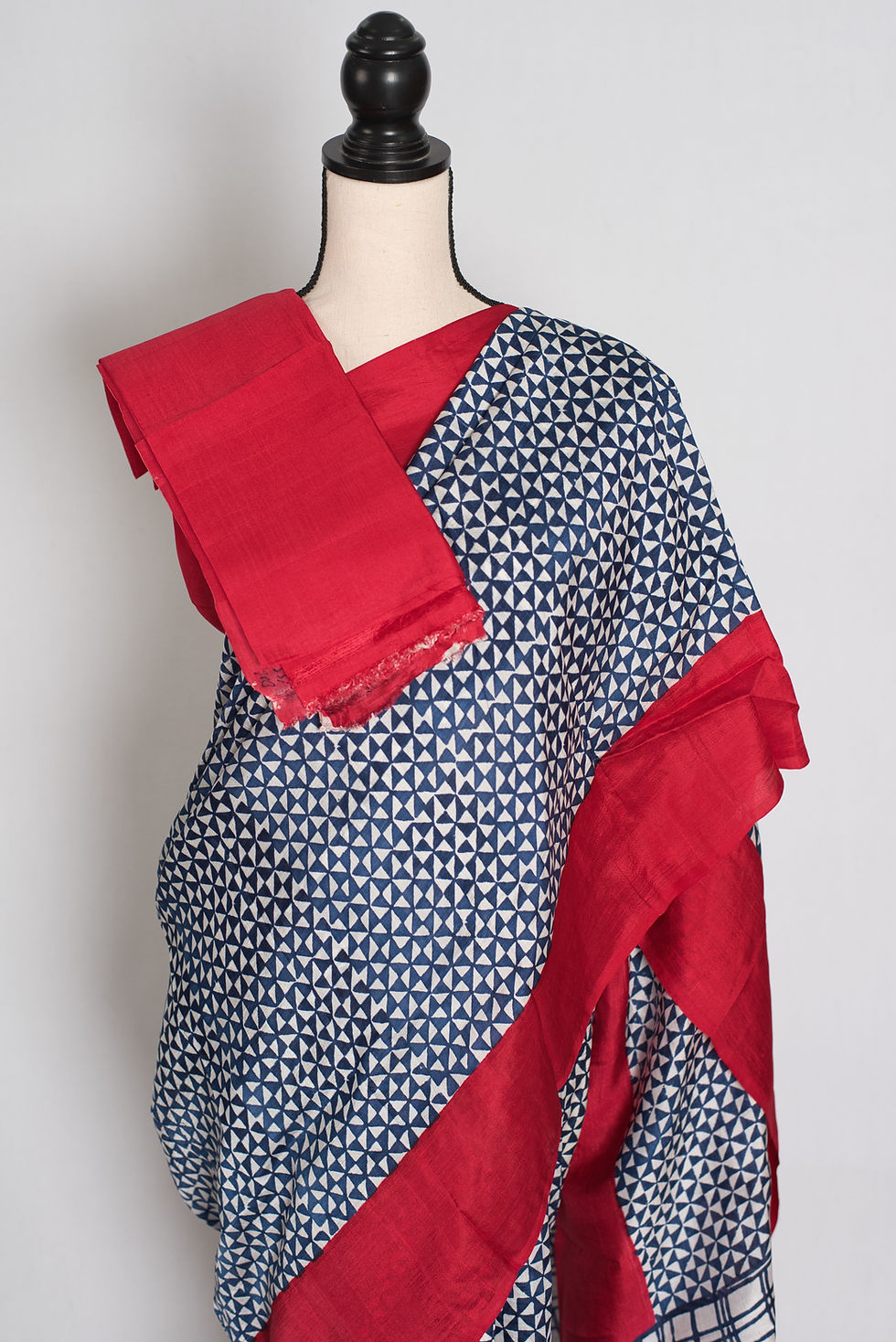 Thumbnail: Blue and red Murshidabad silk saree with a contemporary hand block printed geometric triangle design draped on a mannequin.