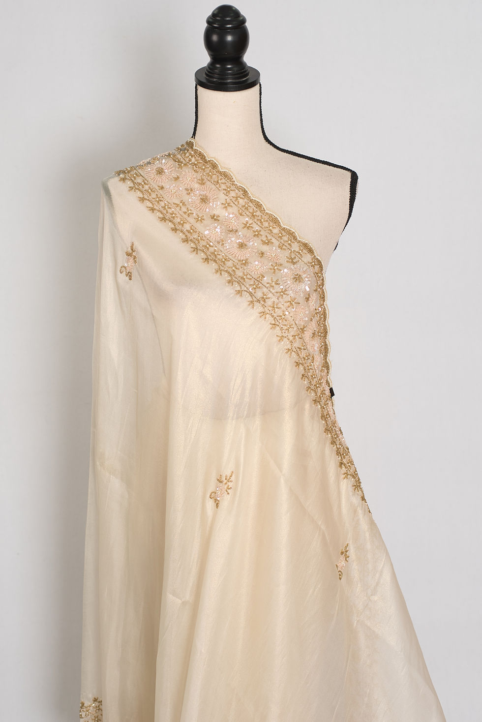 Thumbnail: Front full-length view of the cream and gold soft tissue partywear saree draped on a mannequin.
