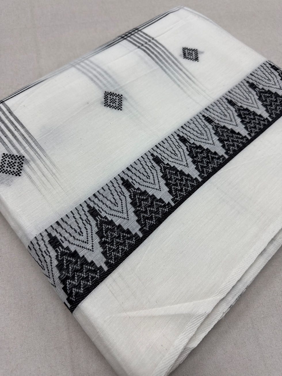 Off-white and black handwoven Bengali soft cotton Dhaniakhali saree with diamond butis and black temple border.
