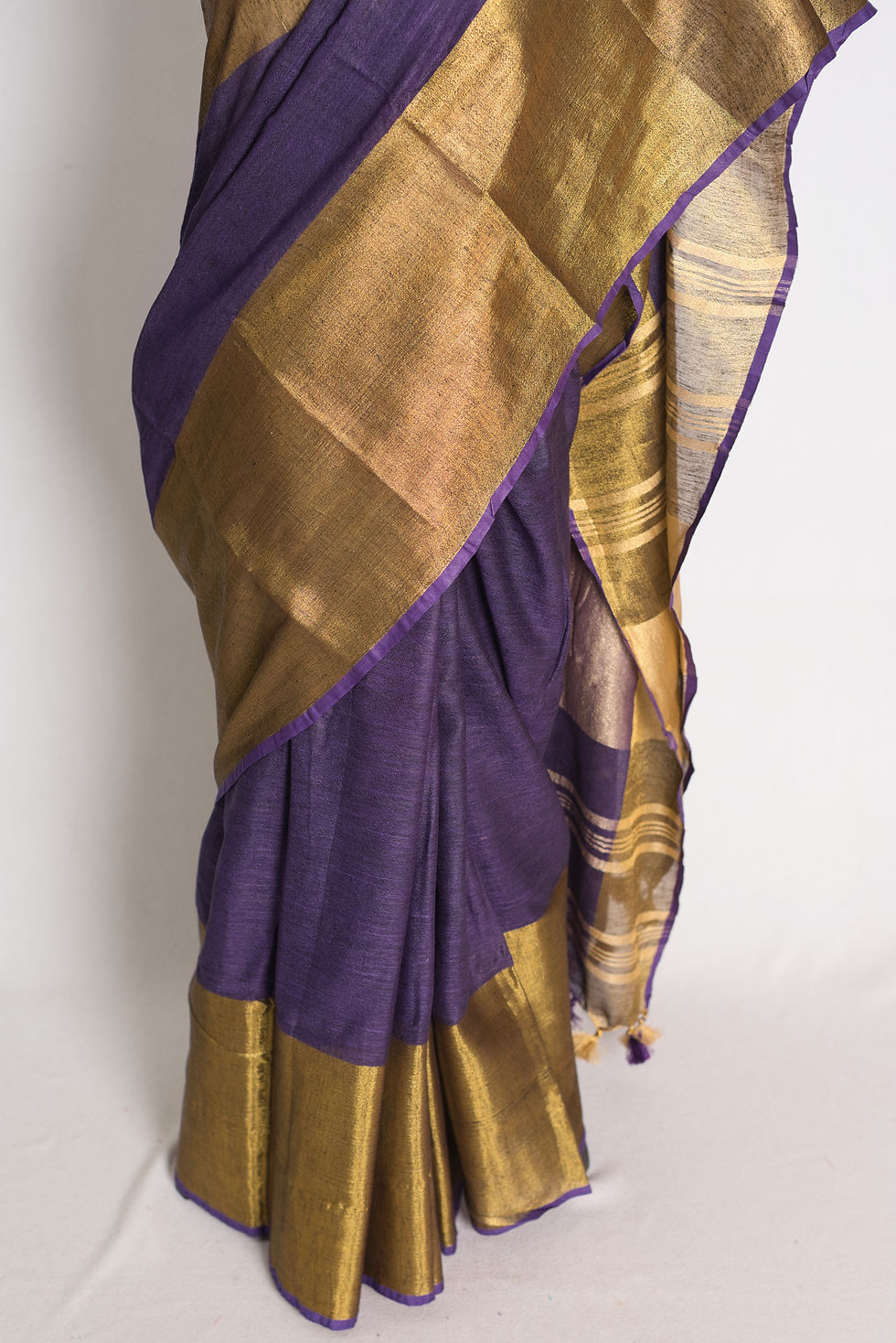 Thumbnail: Purple pure linen saree with wide golden border draped on mannequin.
