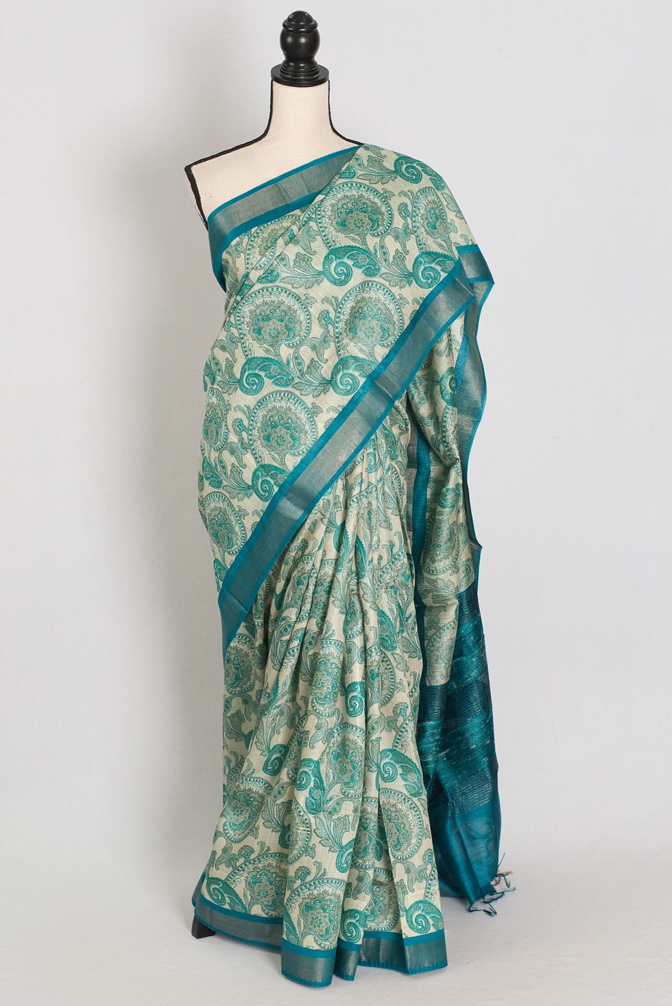 Vidhi block printed Muga Tussar silk saree in off-white and turquoise blue with paisley motifs.