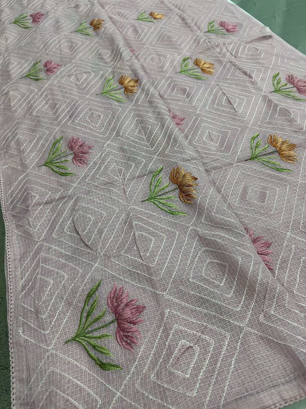 Laila collection: Soft lavender semi kota silk saree with pink and gold floral machine embroidery and geometric weave.
