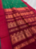 Gayetri dark green blended cotton Gadwal saree showcasing the contrast dark red pallu with antique zari work.