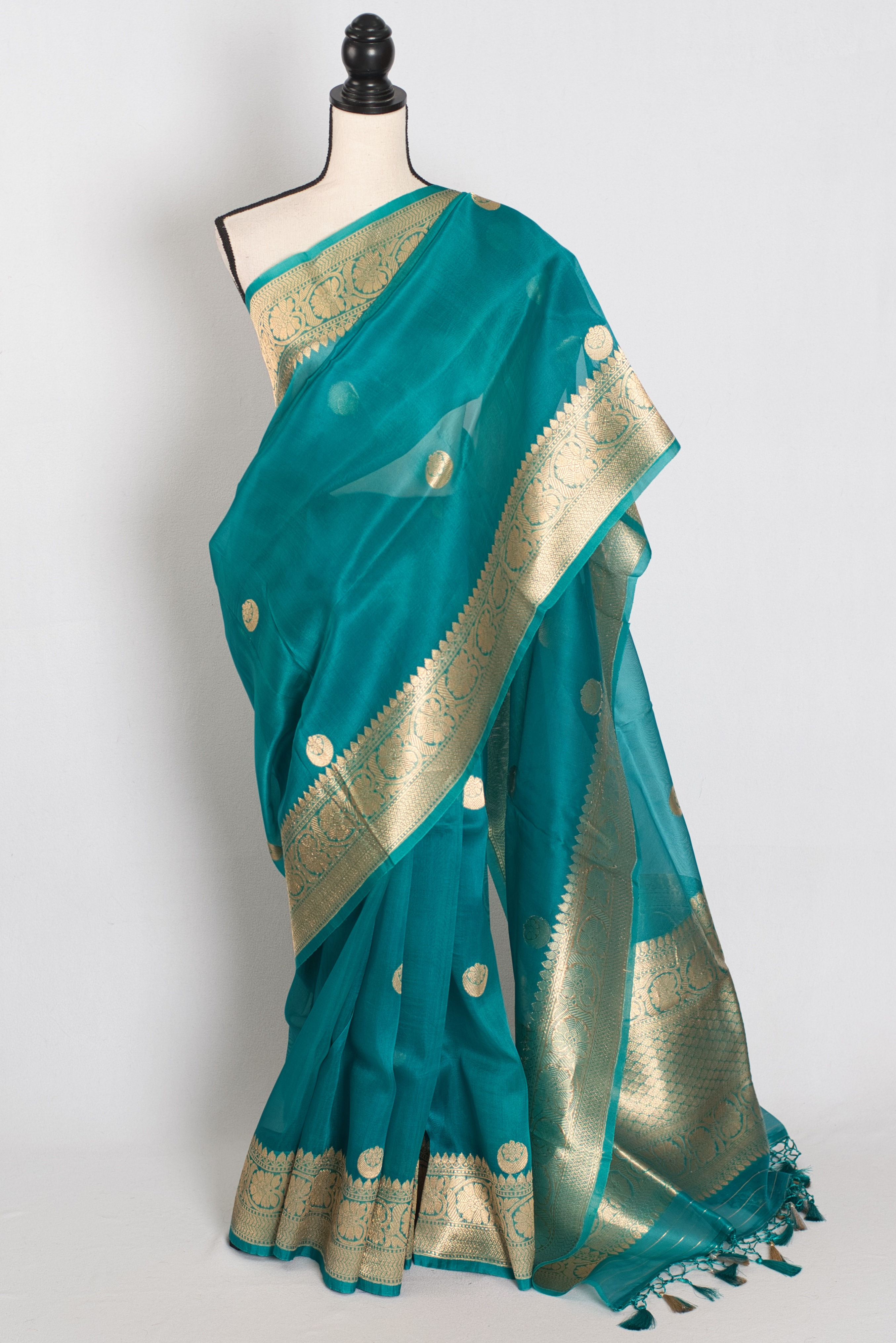 rama green and gold kora organza banarasi saree featuring hand woven chand sitara motifs on a mannequin drape.
