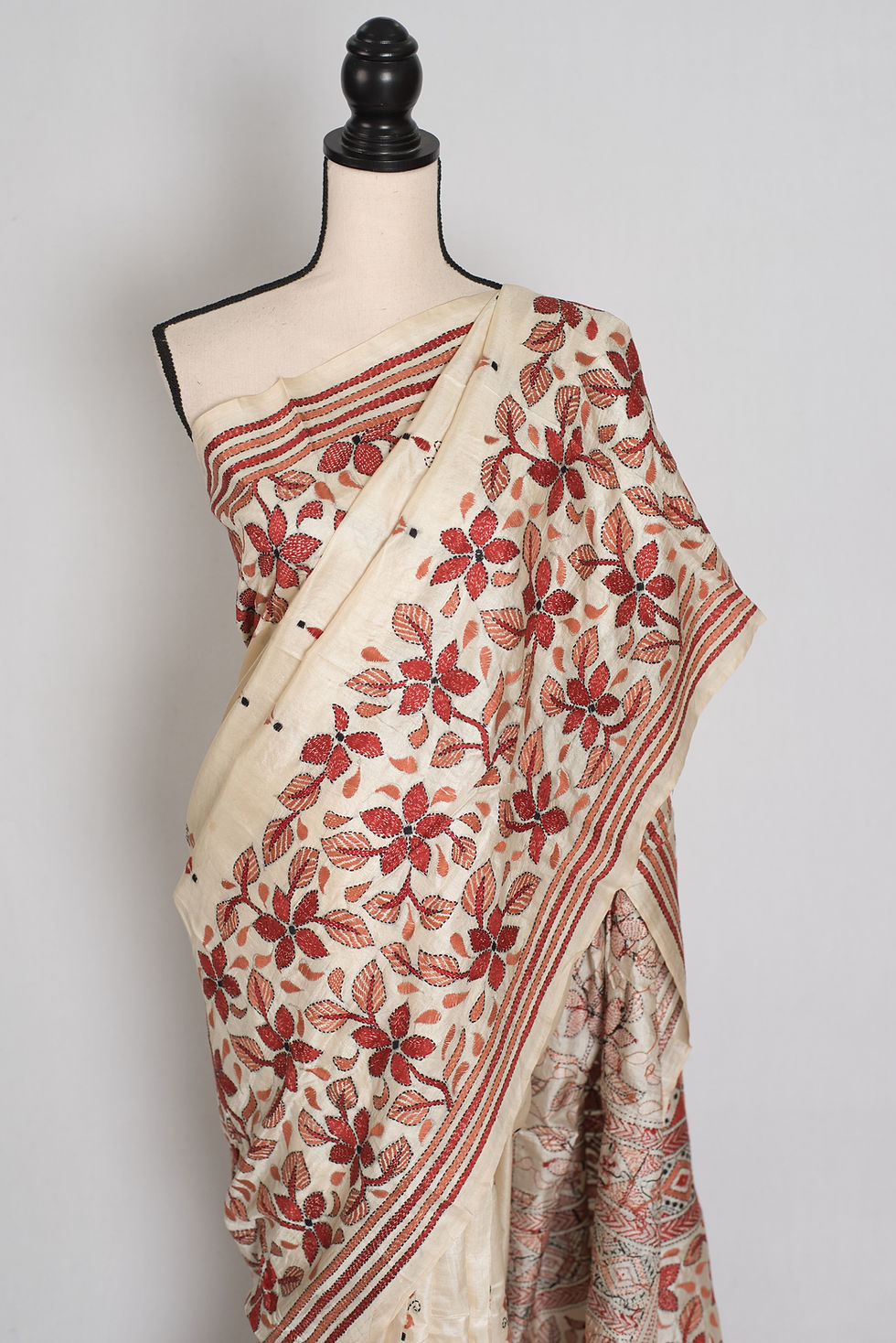 Thumbnail: Cream pure Bangalore silk saree with rust brown hand-embroidered Kantha stitch floral vines draped on a mannequin.
