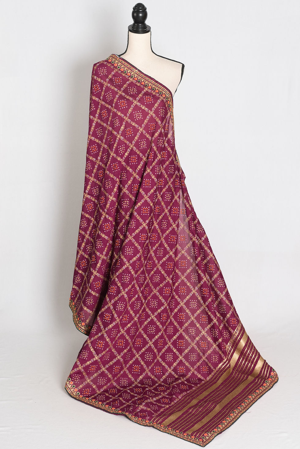 Purple Gharchola gold printed saree with stitched embroidery border draped on a mannequin, showcasing the full length.