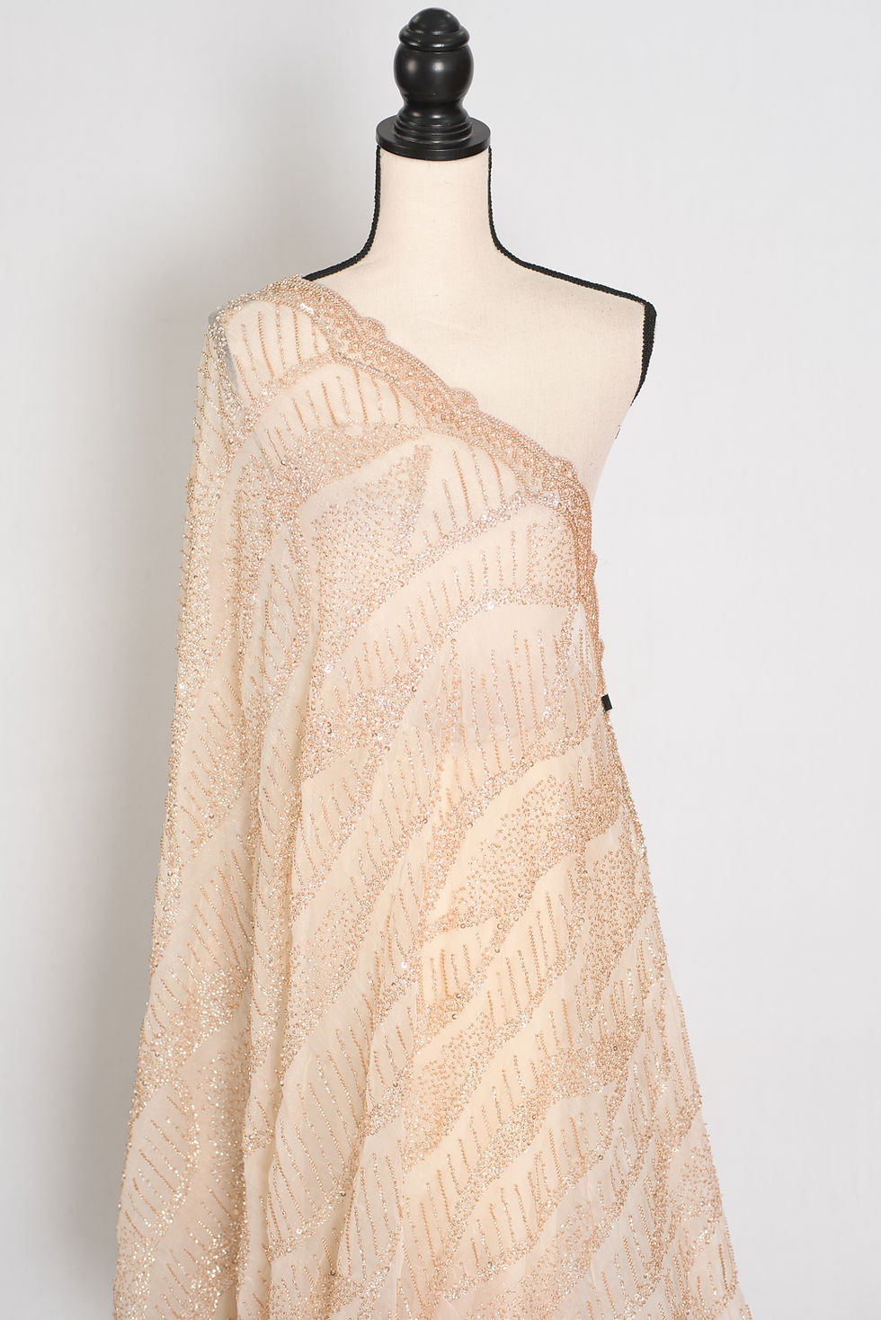 Thumbnail: Cream and gold soft organza partywear saree on a mannequin showing gold sequin embroidery.