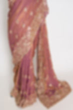 Thumbnail: Soft peach purple organza partywear saree on a mannequin displaying heavy designer embroidery and metallic shimmer finish.