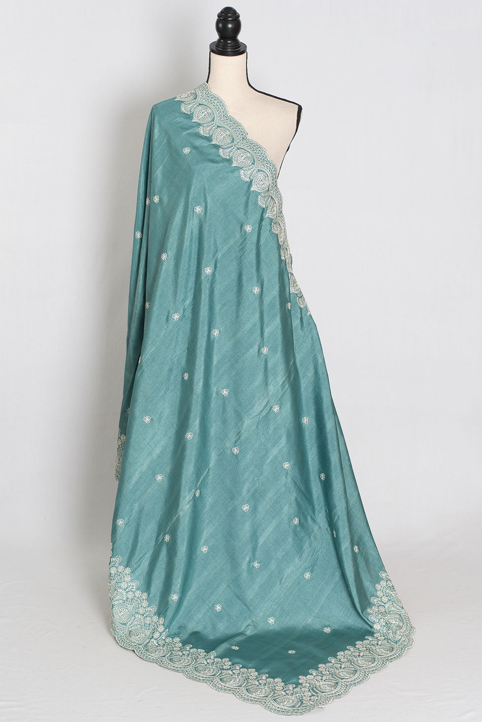 Pastel blue semi tussar silk saree on a mannequin displaying its soft fluid drape and intricate white thread embroidery.