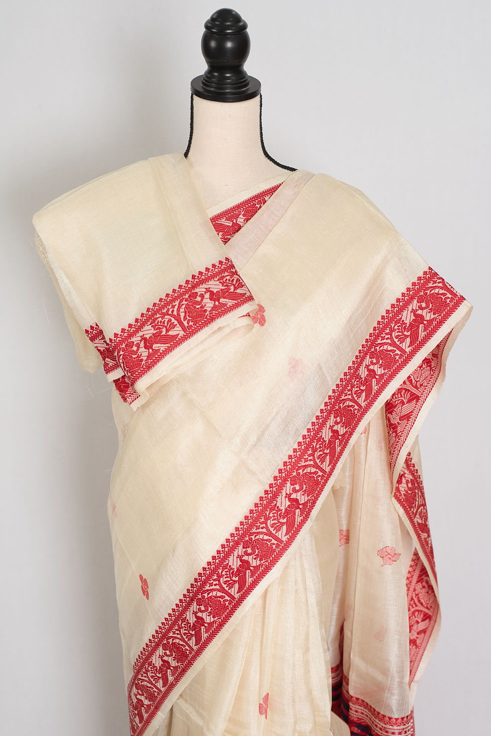 Thumbnail: Traditional cream and red Tussar silk saree with red border on a mannequin, classic Bengali style.