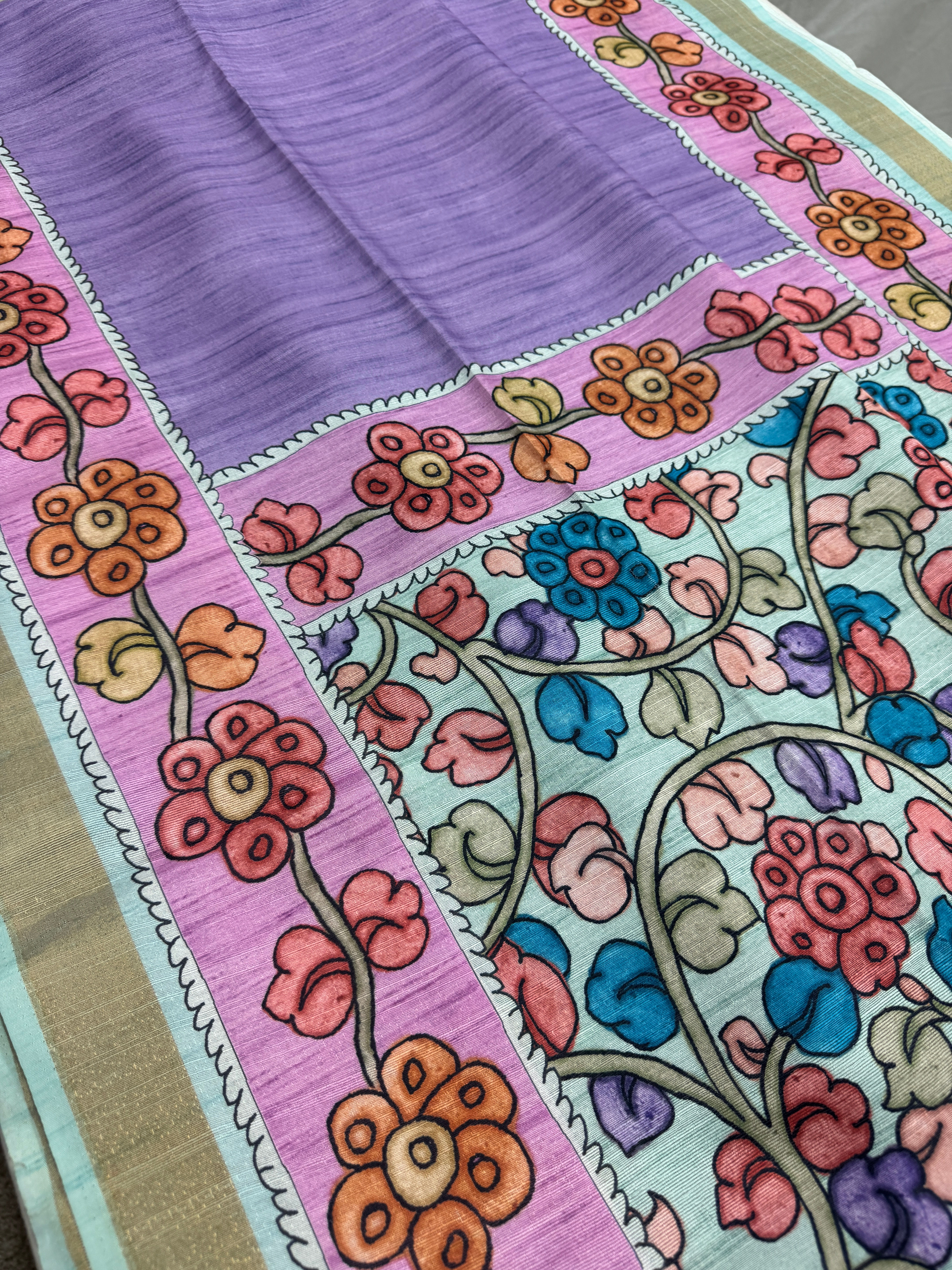 Ila collection Purple Semi Tussar Saree with sky blue Kalamkari floral print and gold border.
