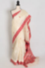 Traditional cream and red Tussar silk saree with red border on a mannequin, classic Bengali style.