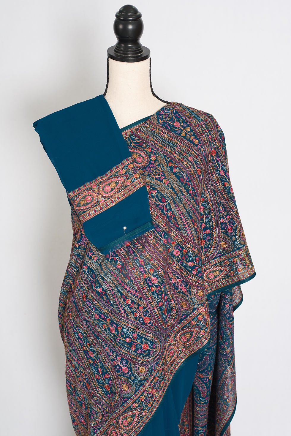 Thumbnail: Cobalt blue georgette partywear saree on a mannequin displaying all-over multicolor Kashmiri machine embroidery jaal.